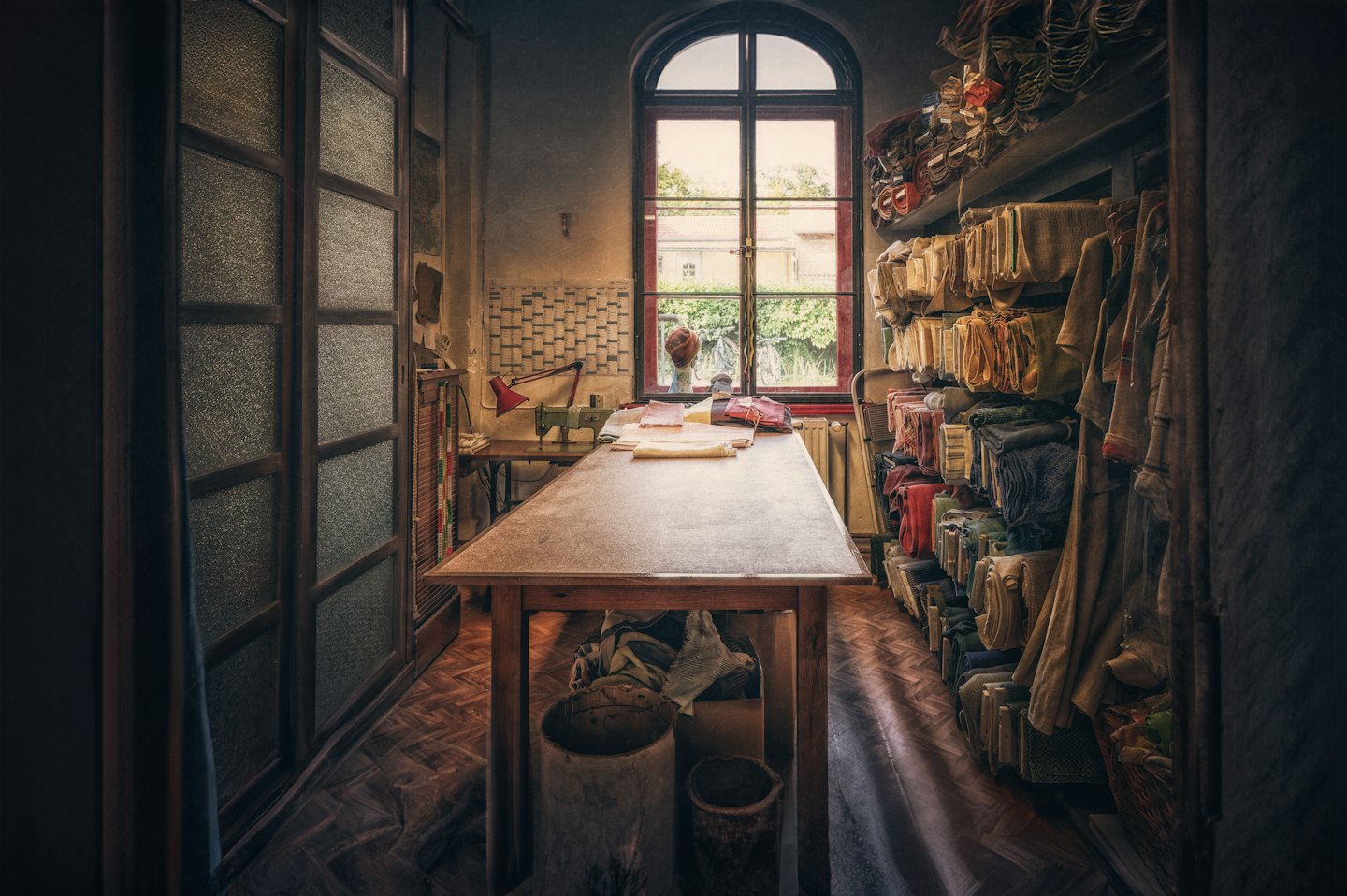 Tailor's workshop with sewing machine and fabric bolts.